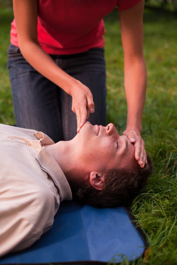 Girl performing first aid on a man
